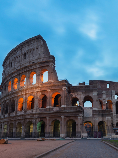 photo shows the colosseum colloseo against a bright blue sky